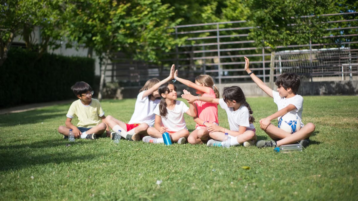 A group of children sitting and interacting on a sunny day in Portugal.